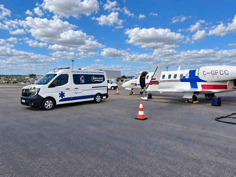 Ambulance Dromoise sur le tarmac d'un aéroport, à côté d'un avion sanitaire